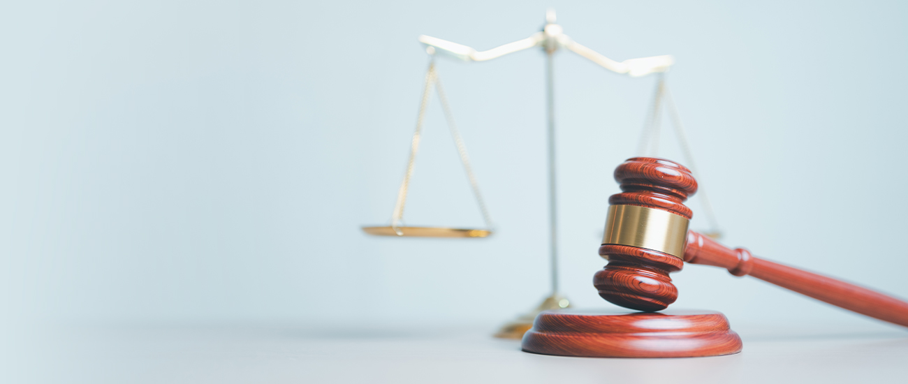 Judge's gavel with scales of justice in the background